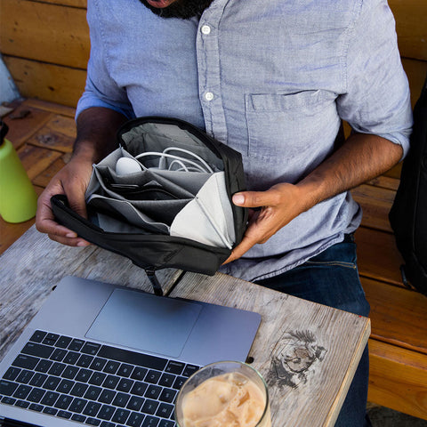 Alvin using his black tech pouch for his laptop accessories